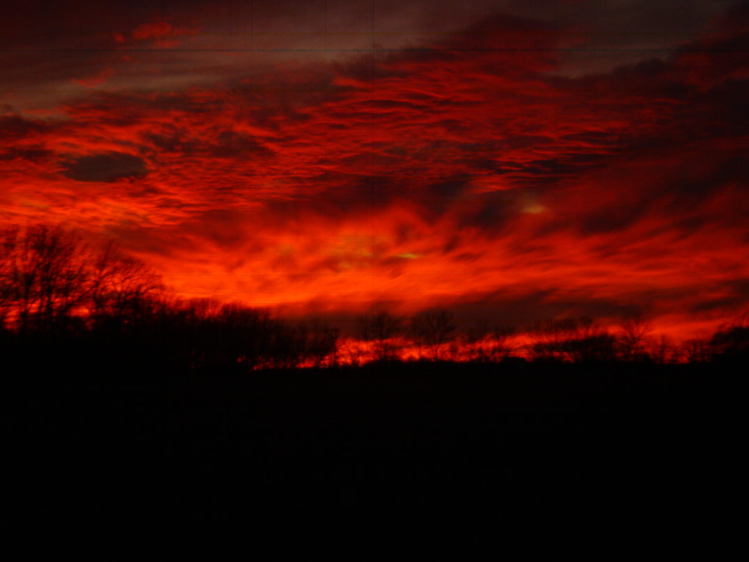 An apocalyptic, dark-red sunset with dramatic clouds.
