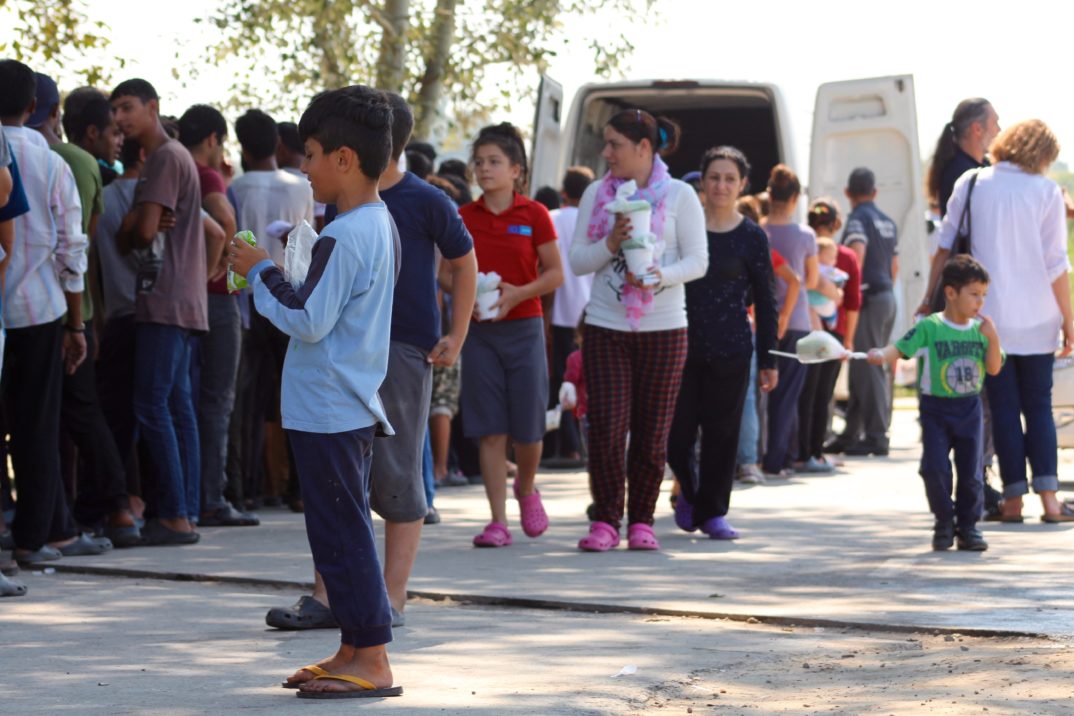 "Refugees queue for hot food in a camp on the Serbia Hungary border" by Trocaire liscensed under CC BY 2.0 (via Flickr)