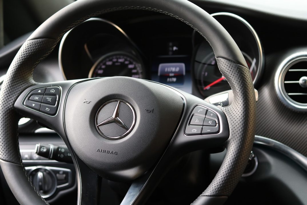 A photo of the steering wheel of a Mercedes car.