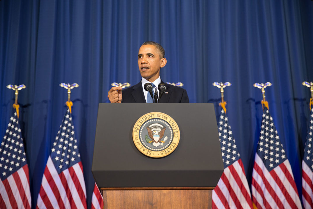 A photo of Barack Obama speaking behind a podium.