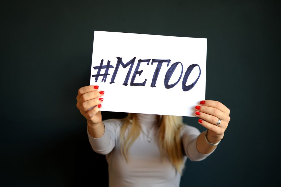 An anonymous woman holding up a sign that says #MeToo