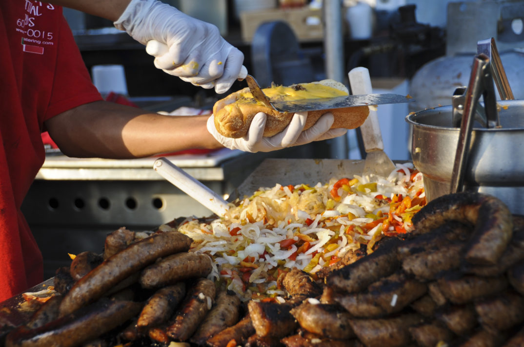 An image of a street food vendor preparing a sandwich