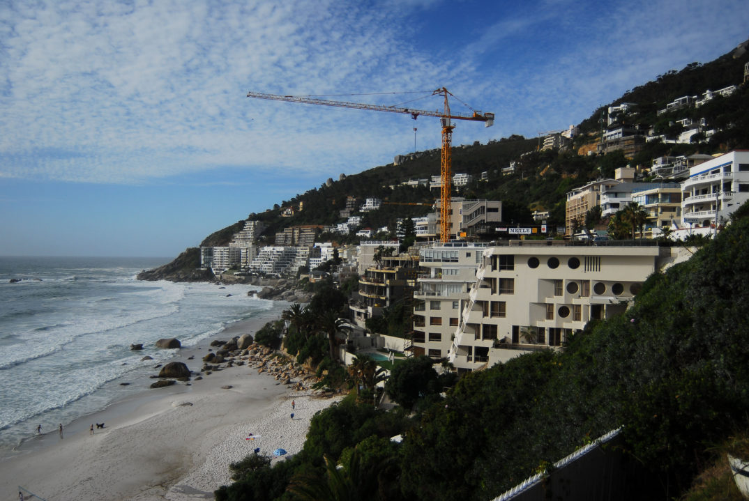 Photo of the coast of Cape Town showing high rise buildings and a crane