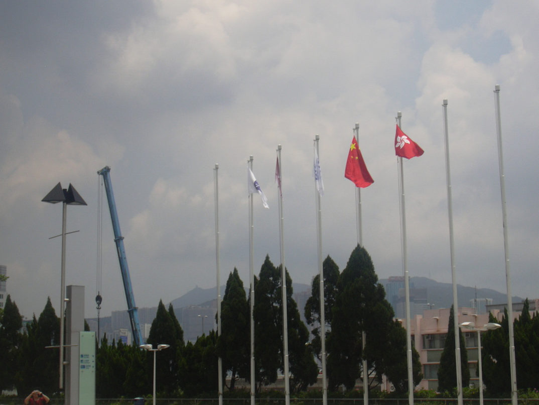 Photograph of several flagpoles, with Chinese and Hong Kong flags visible