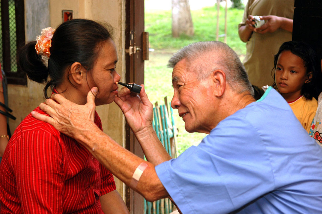 Photo of a doctor giving an eye exam to a child.