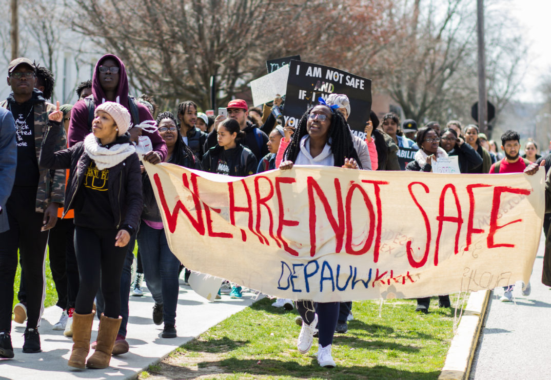 Image of students with banner that reads "We are not safe"