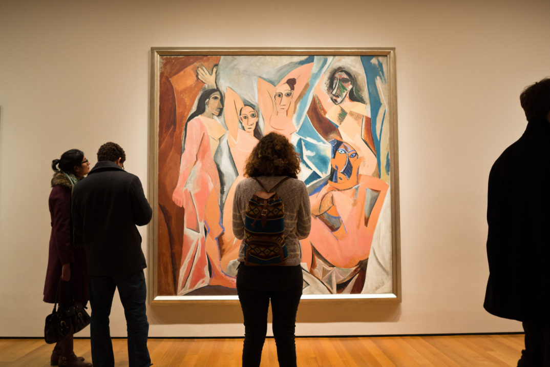 Silhouettes of people in front of Picasso's painting "Les Demoiselles d'Avignon"