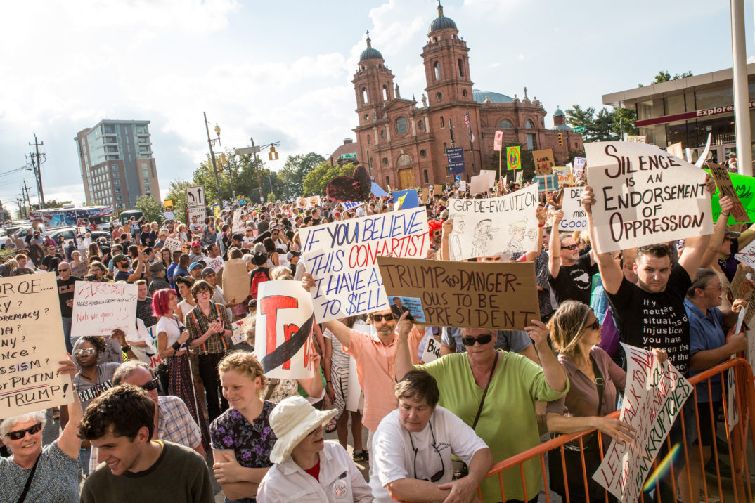 Photograph of many people holding signs at a political rally