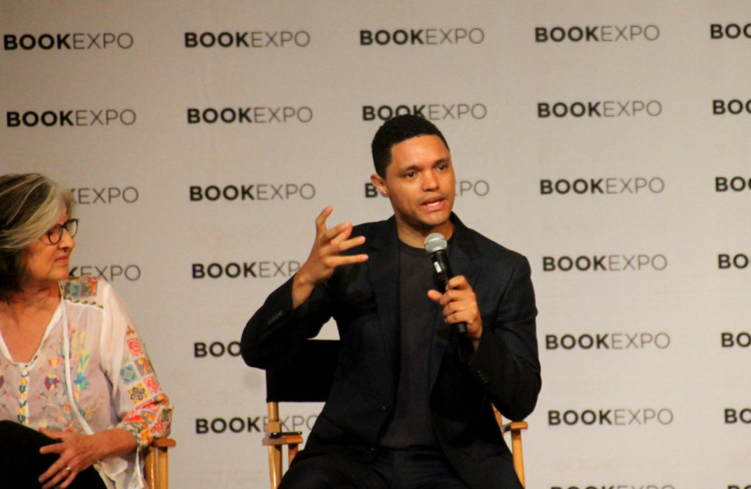 photograph of Trevor Noah speaking into a microphone
