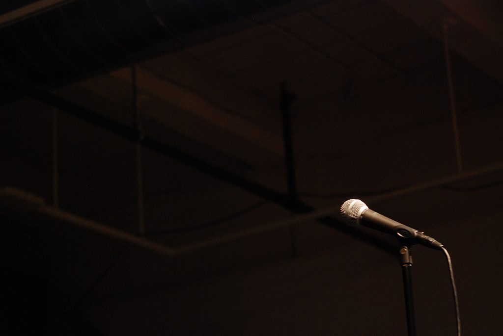 photograph of a microphone and a dark background