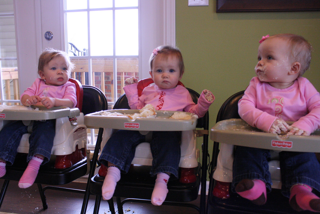 Photograph of three toddlers dressed in pink