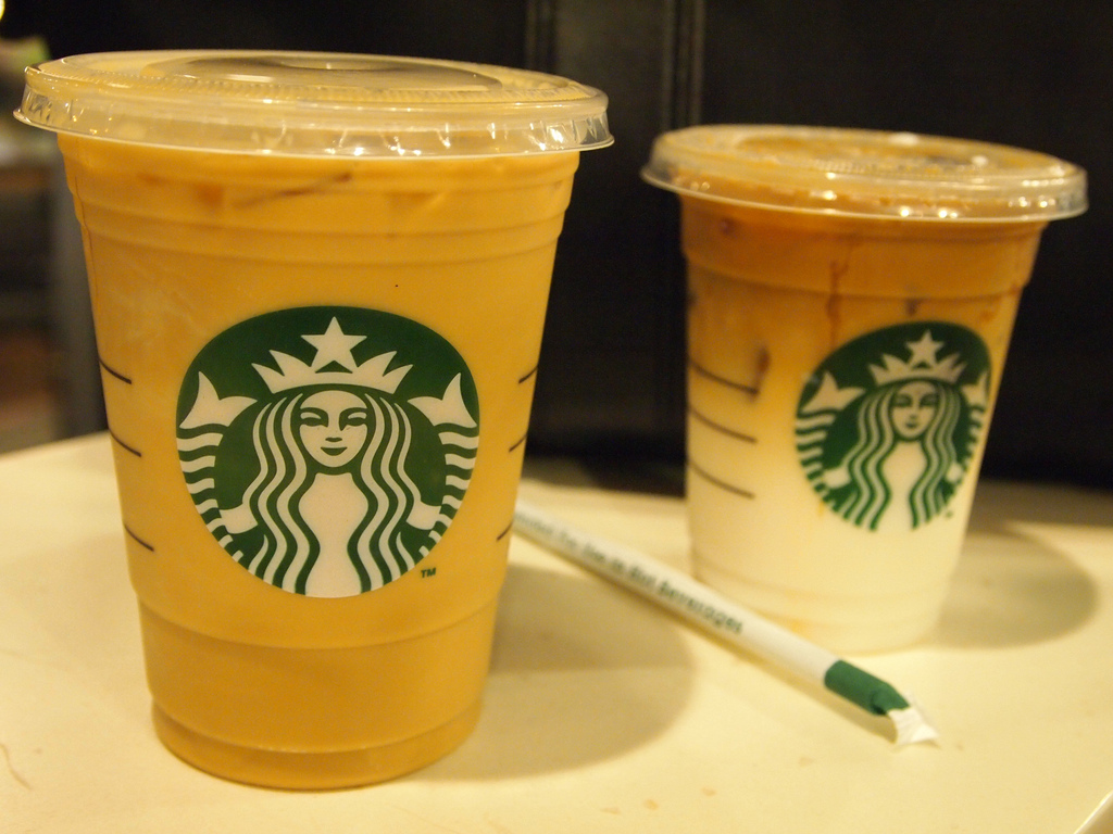 Photograph of two iced Starbucks drinks with a wrapped straw in between them