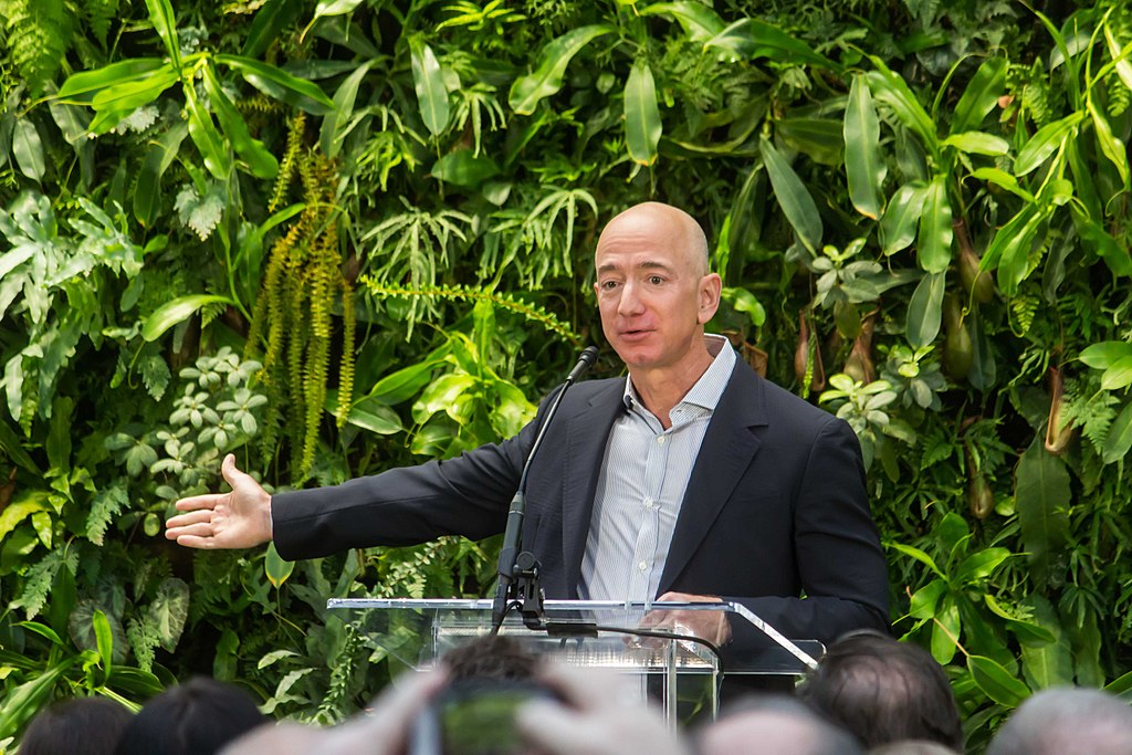 Photograph of Jeff Bezos speaking at a podium and gesturing with arm