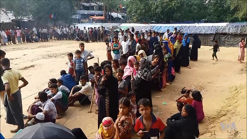 Photograph of a long line of people in a refugee camp