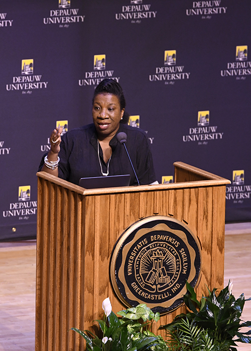 Photograph of Tarana Burke standing at a podium with a DePauw University backdrop