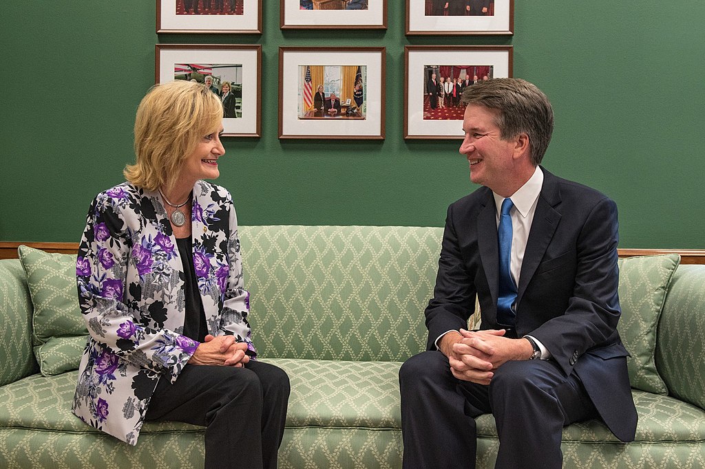 photograph of Mississippi senator Cindy Hyde-Smith and Brett Kavanaugh smiling while sitting on a couch