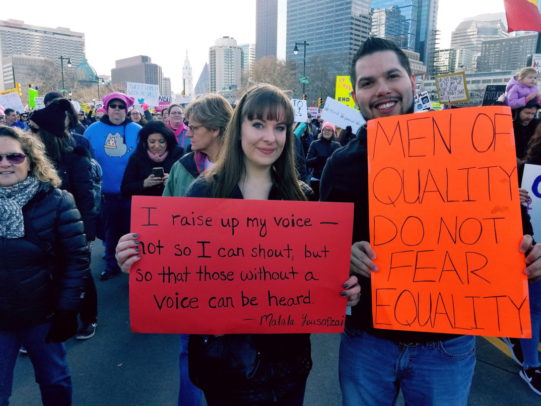 Photo of two people holding signs at a protest