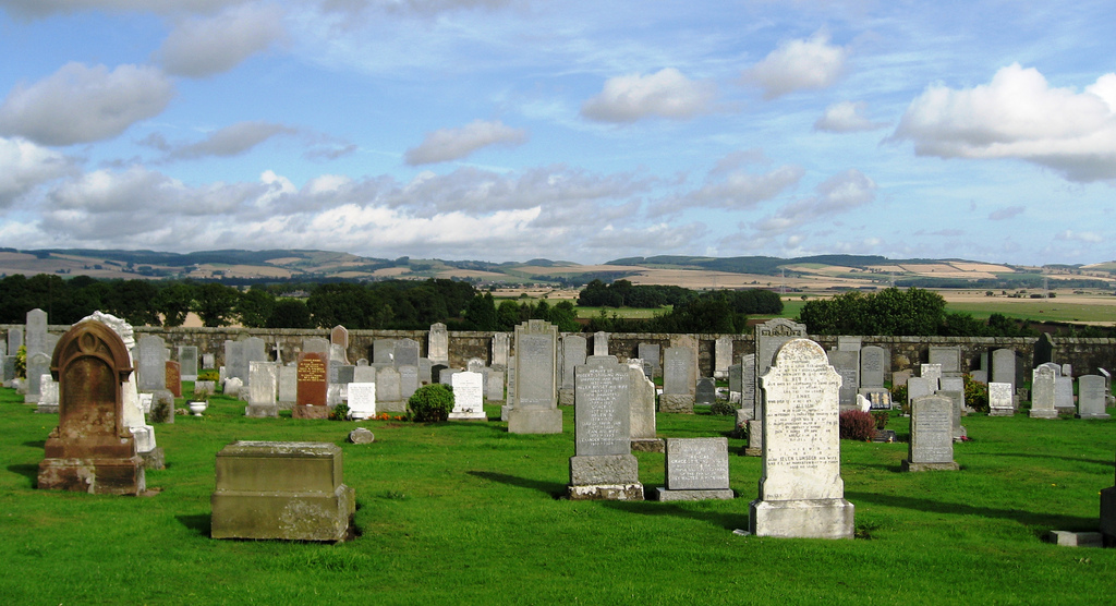 Photograph of a graveyard overlooking hills and plains