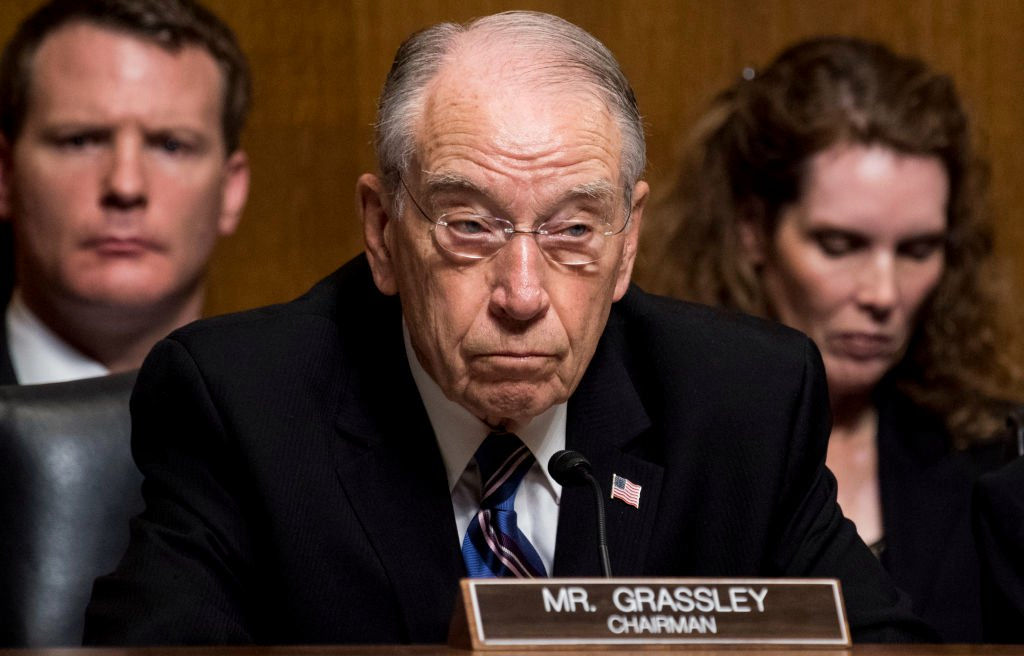 Image of Sen. Grassley with two people behind him