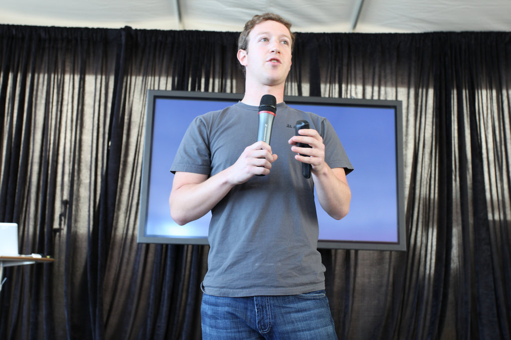 Photograph of Mark Zuckerberg standing with a microphone