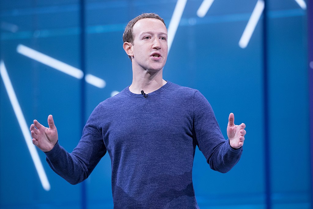 Mark Zuckerberg giving a speech against a blue background