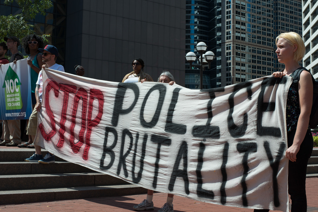 Photograph of protesters holding "Stop Police Brutality" banner