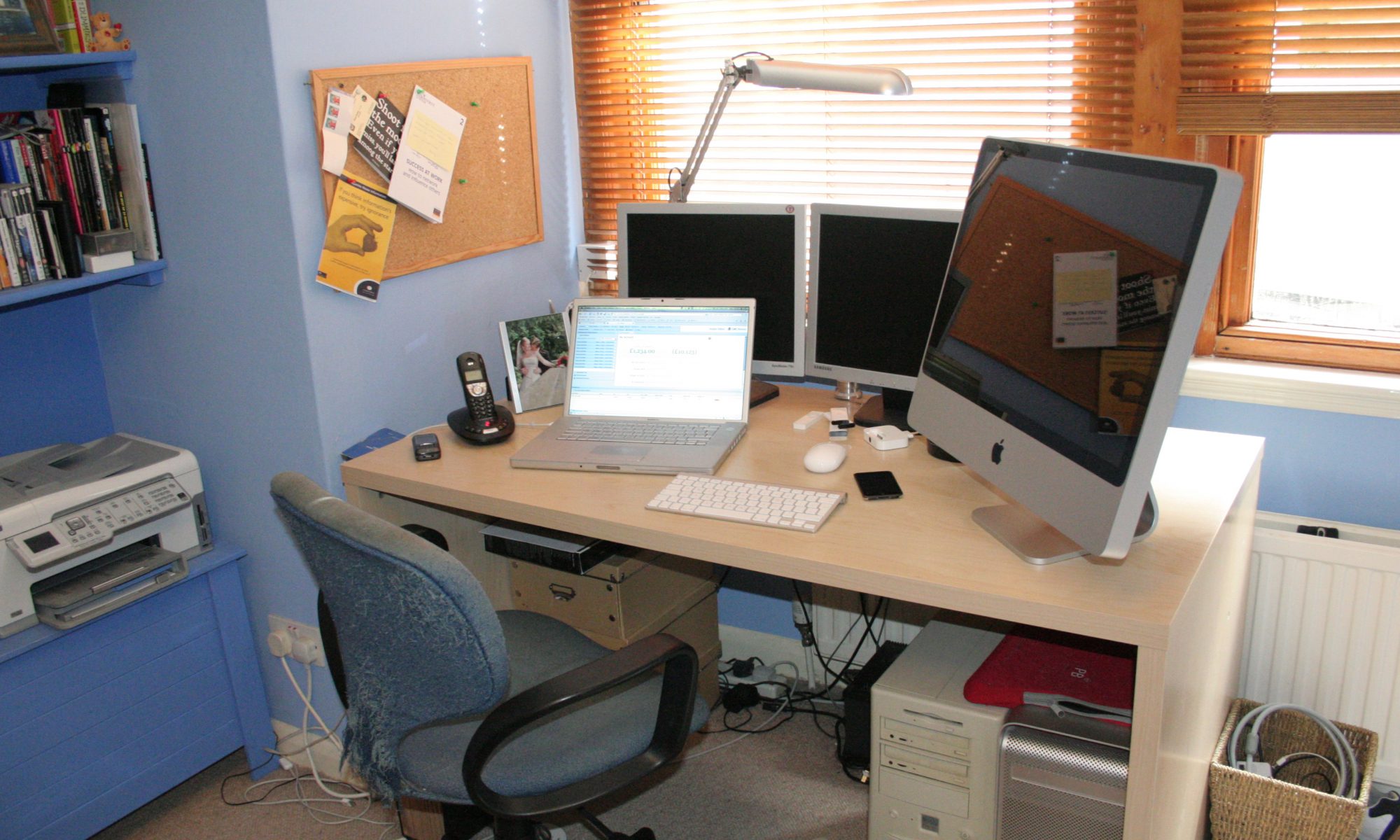 A wooden desk holds up the equipment for an at home office