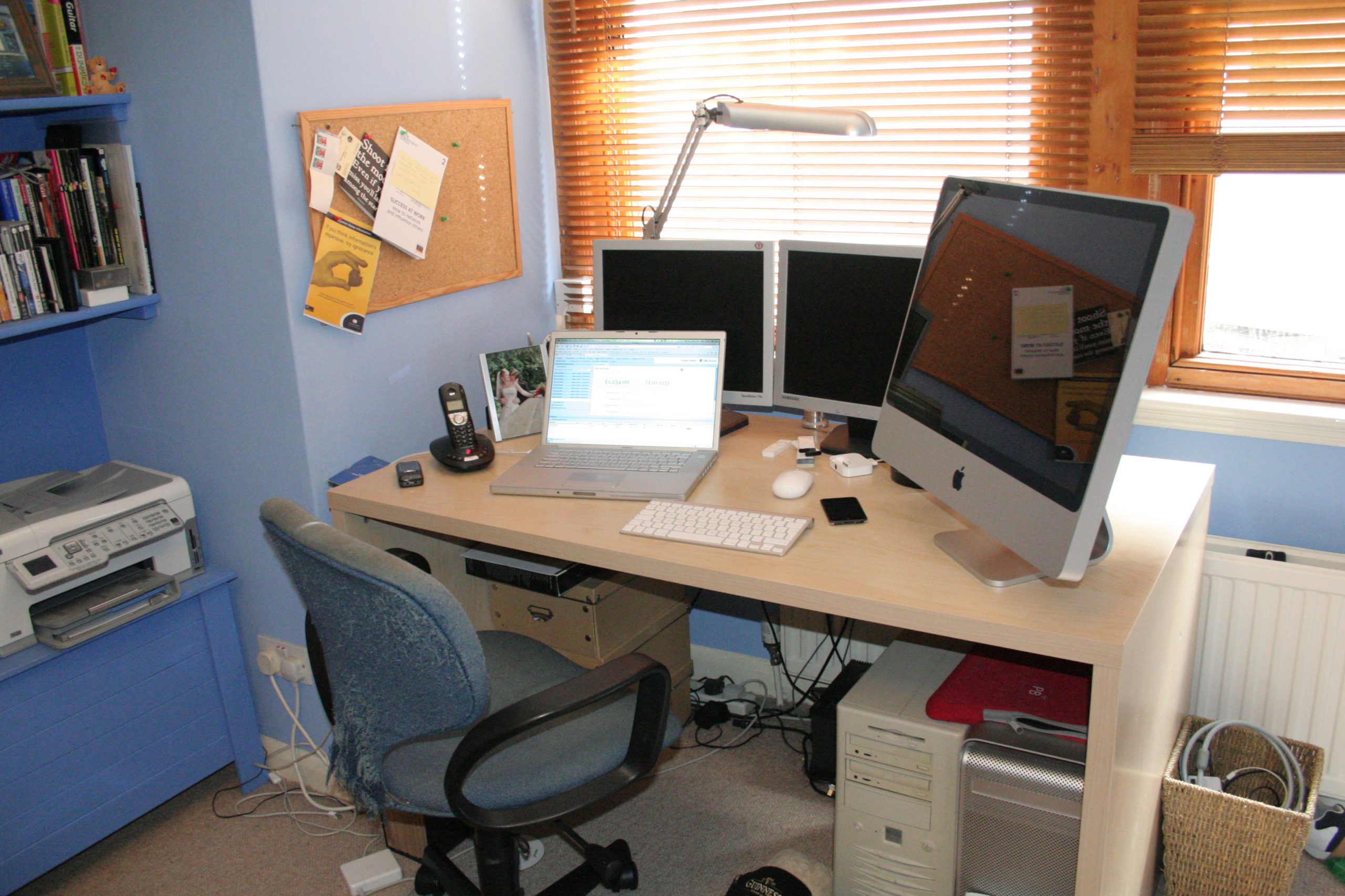 A wooden desk holds up the equipment for an at home office