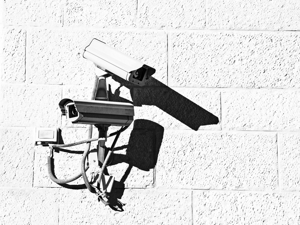photograph of two security cameras on side of building