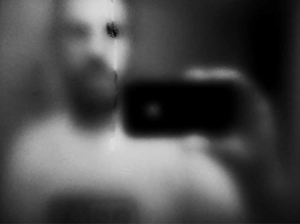 photograph of a man's reflected image on mirror taken by iphone