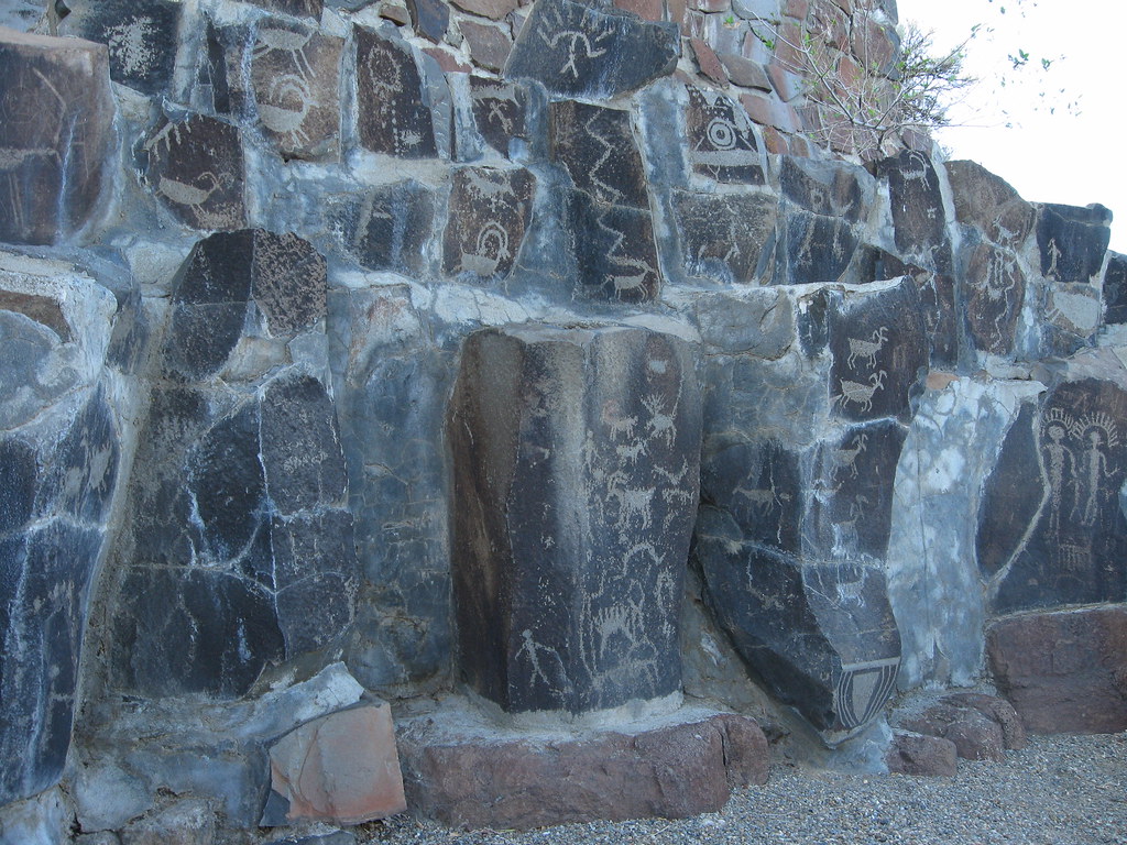 photograph of petroglyphs etched in a number of different stone faces
