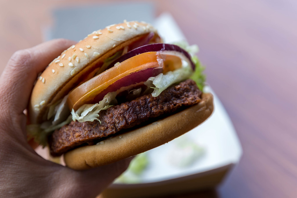 Close-up photograph of a hand holding vegan McDonalds burger