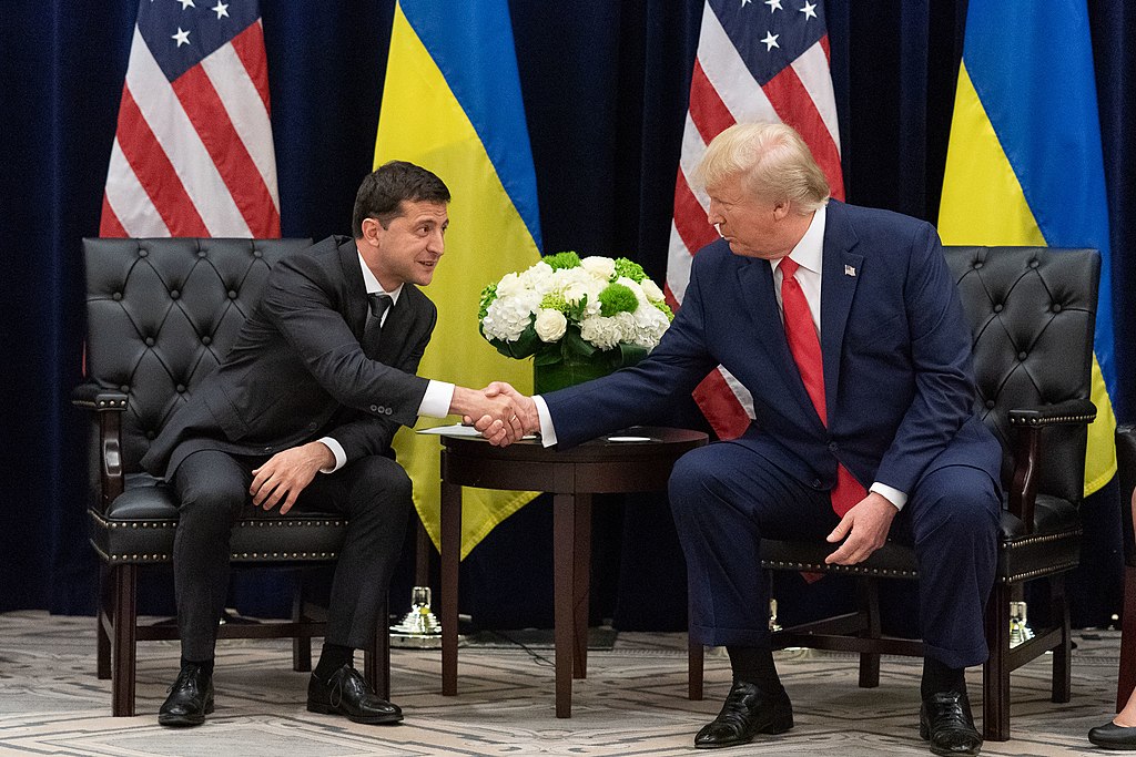 photograph of Trump and Zelensky posing for cameras, seated and shaking hands