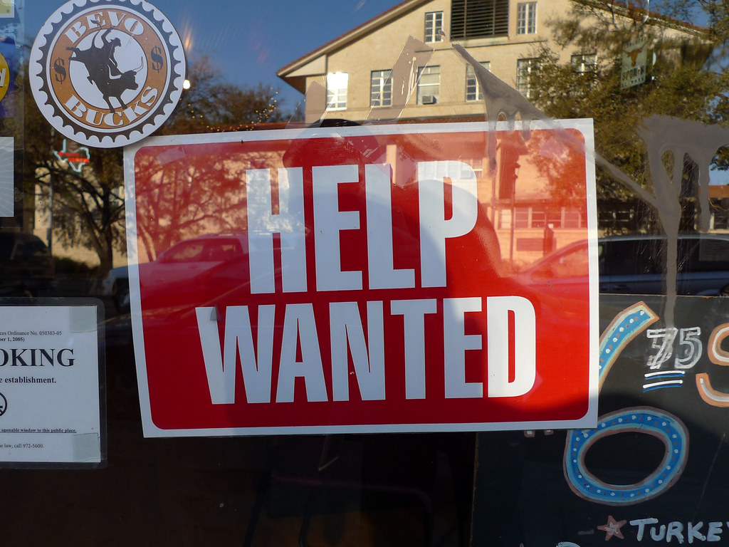 close-up photograph of 'Help Wanted' sign in storefront window