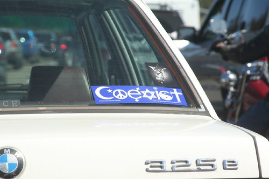 photograph of "Coexist" bumper sticker in back window of a BMW