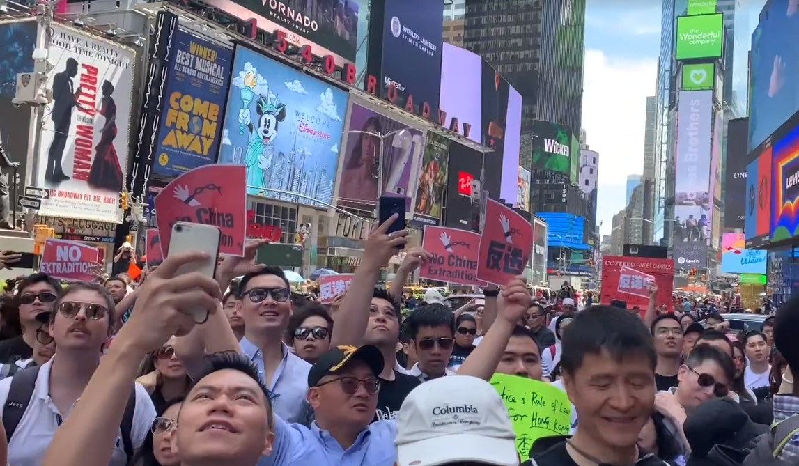 photograph of protest in NYC with many participants streaming on iphones