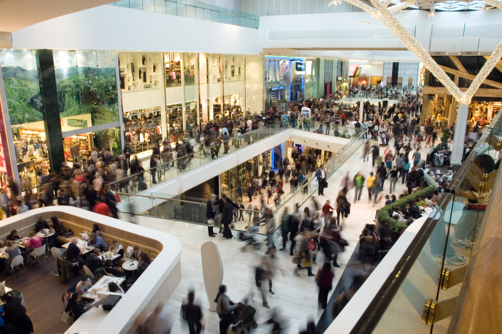 photograph of blurred crowds moving through two-story mall