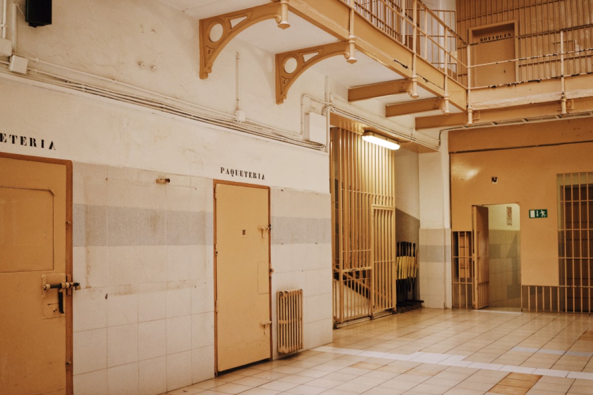 Yellow and white corridor with metallic doors of cell rooms in old prison