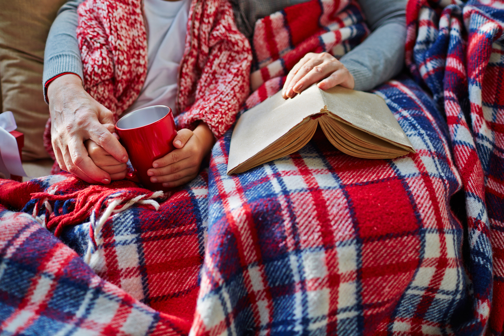 photograph of grandmother and grandson under blankets with a book laid down