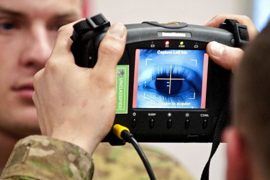 photograph of two army personnel using biometric scanner