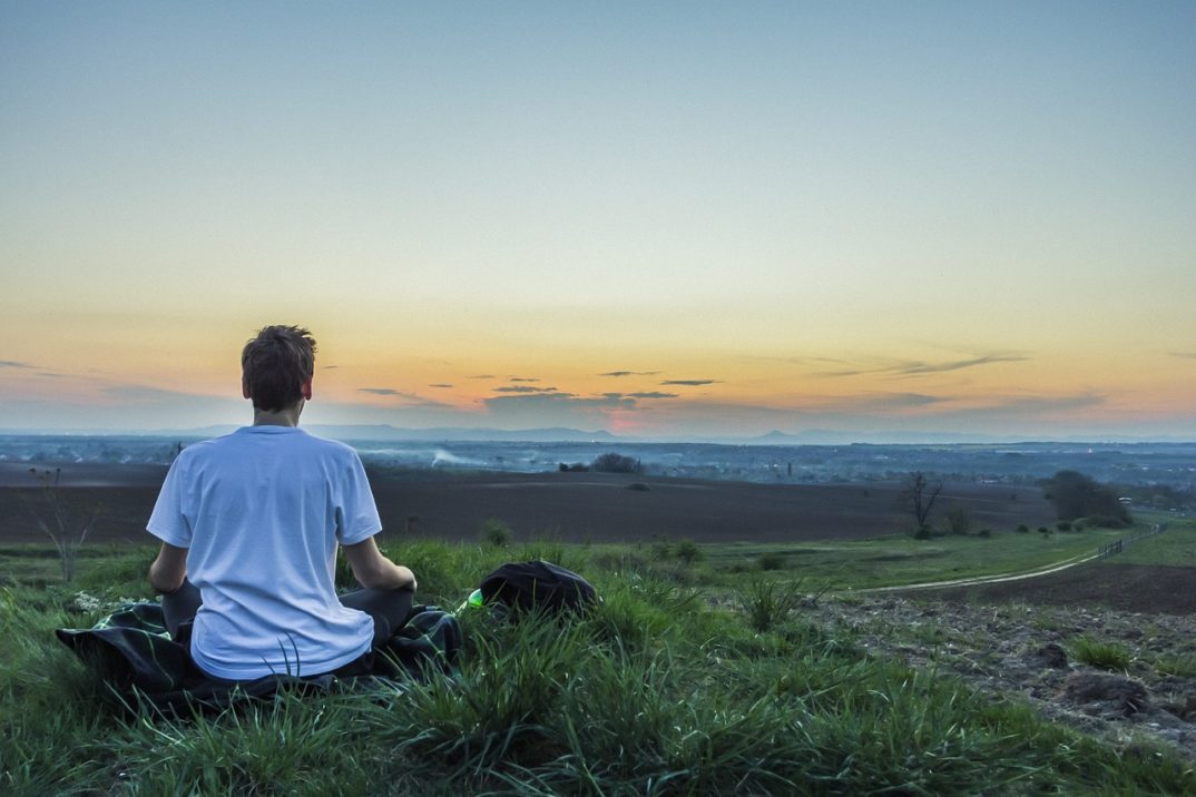 photograph of person meditating before dawn