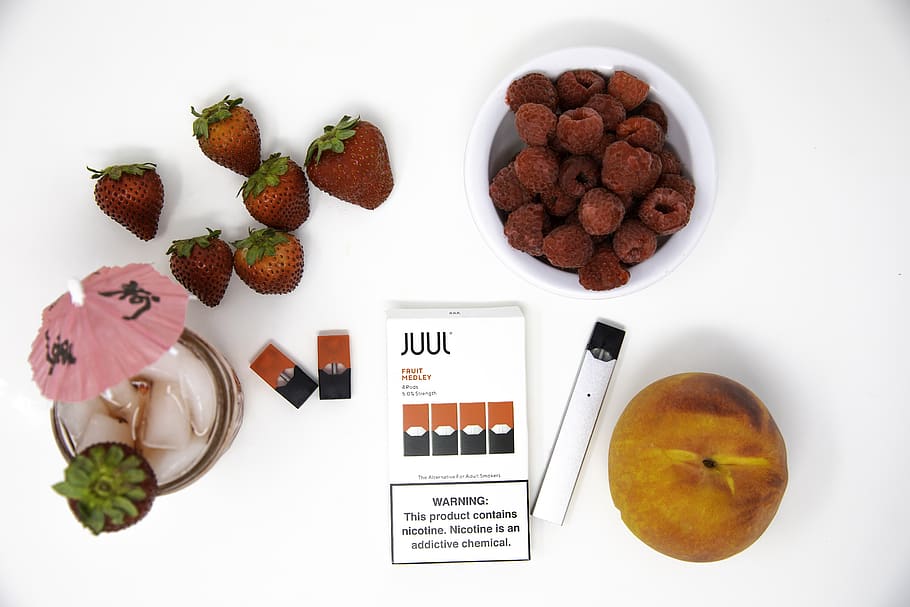 photograph of Juul pods with strawberries, raspberries, a peach, and a cocktail