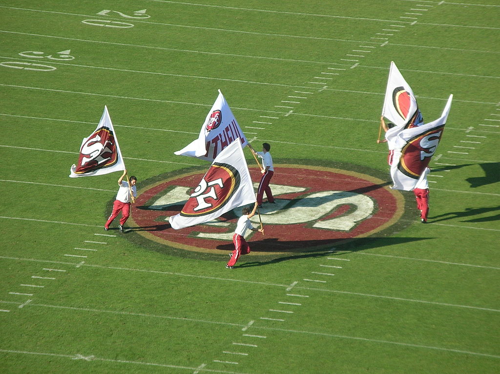 photograph of 49er flagbearers celebrating on field