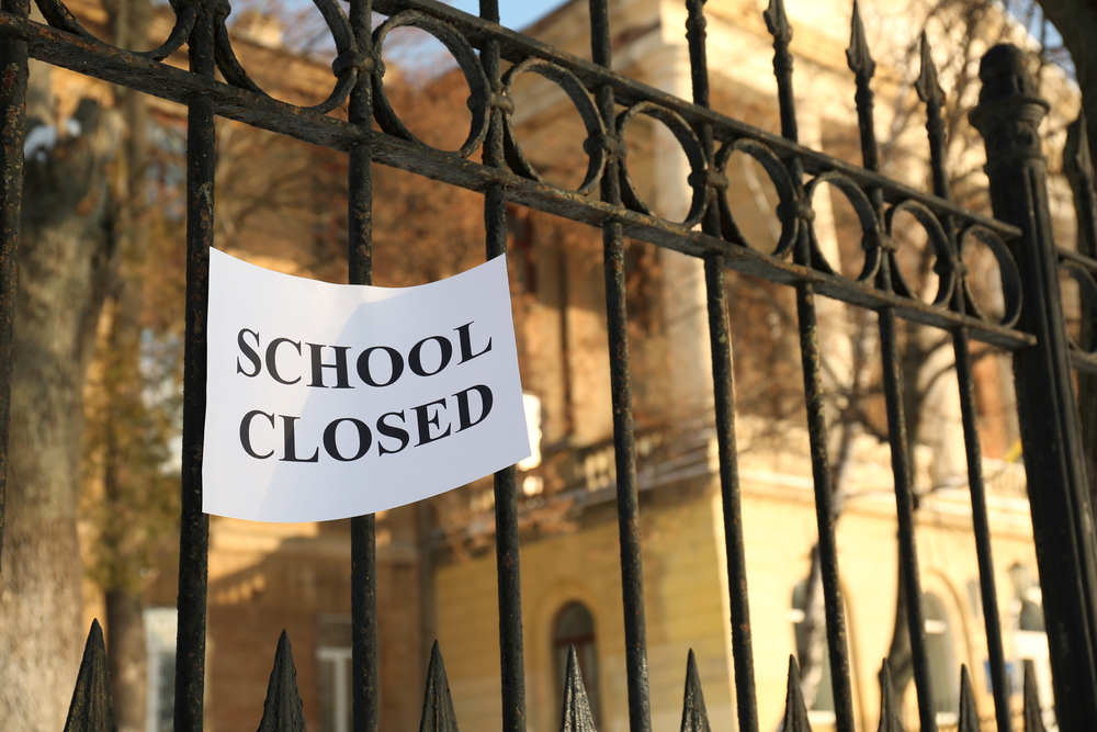 photograph of gate to school with "SCHOOL CLOSED" sign