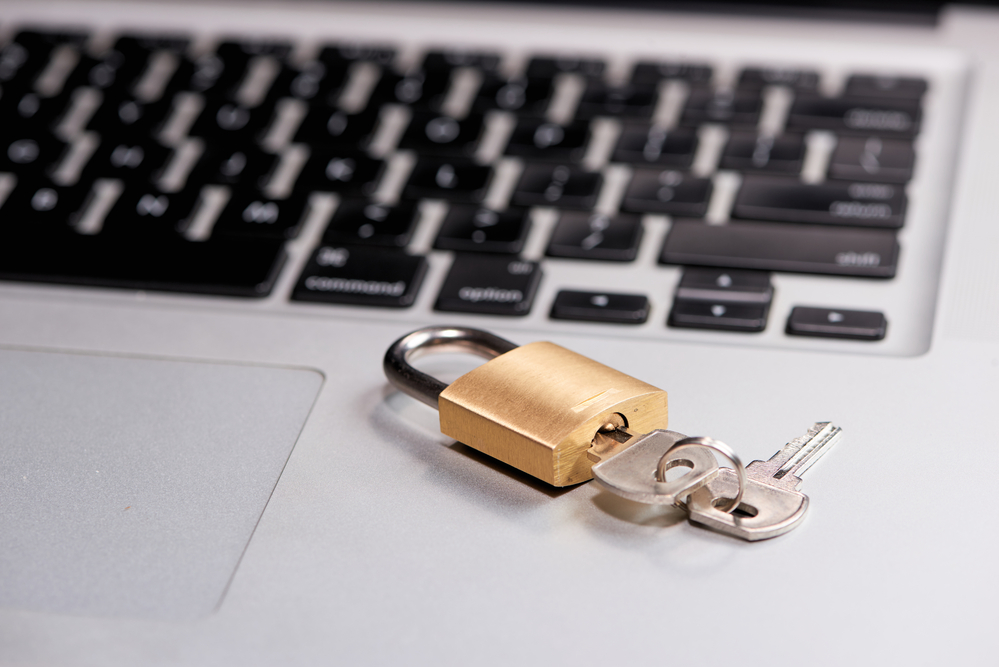 photograph of laptop with a lock with keys on it