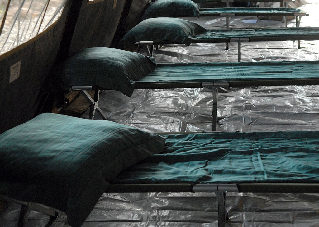 photograph of empty cots in a medical tent