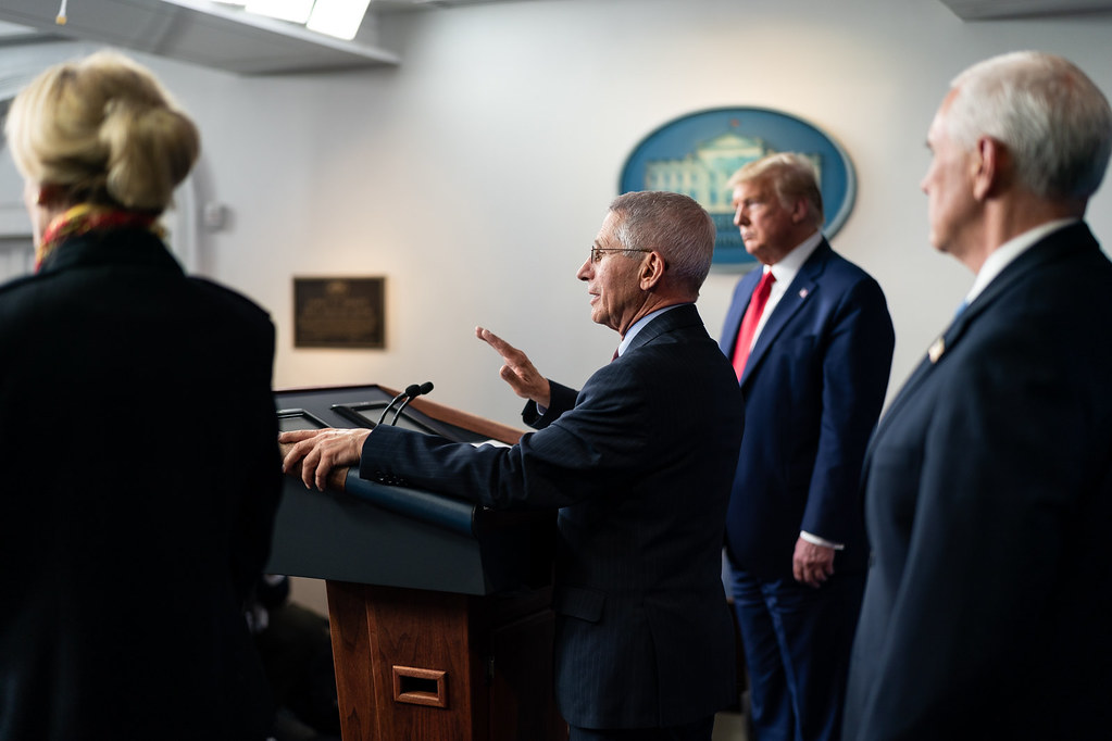 photograph of Coronavirus Update Breifing with Dr. Fauci at the podium with Trump behind him