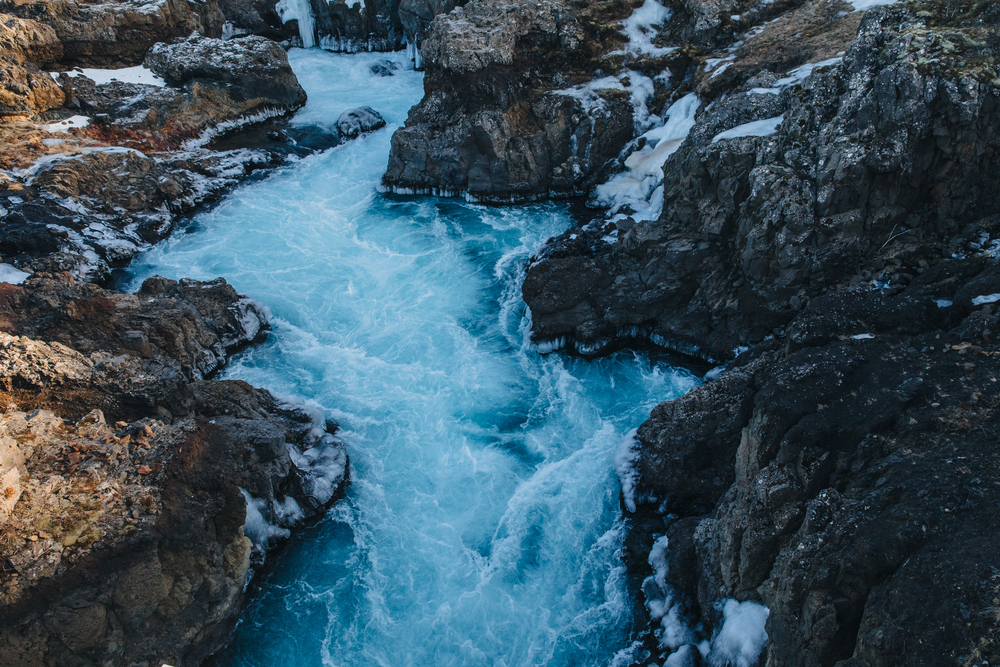 photograph of mountain stream falling through jagged rocks