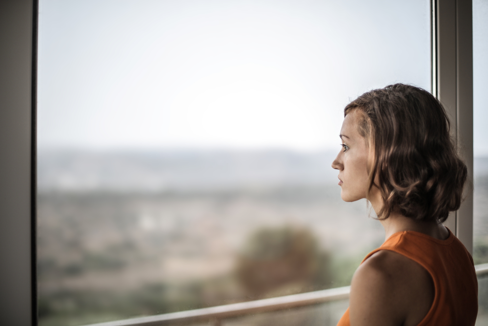 photograph of woman staring off out window