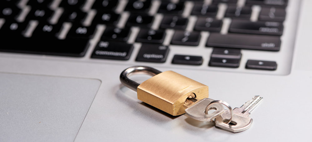 Close up shot of a laptop keyboard with a padlock on top of part of it.